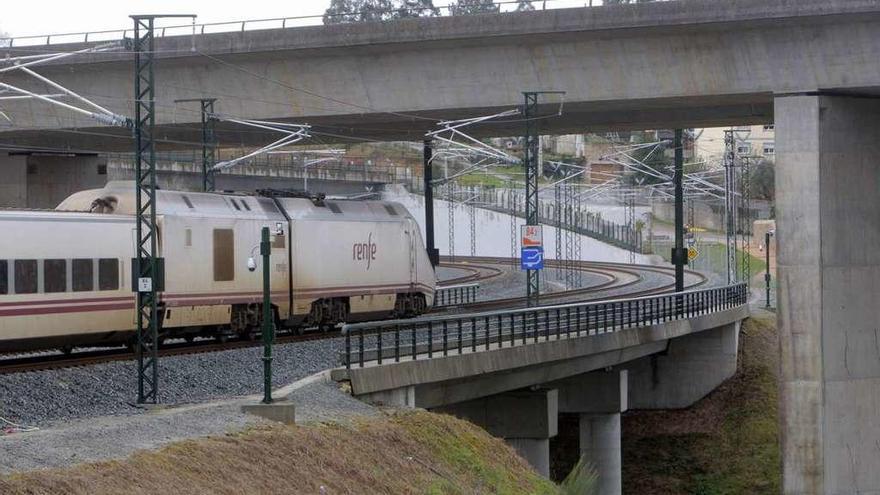 Un tren circula por la curva de A Grandeira en el barrio compostelano de Angrois.