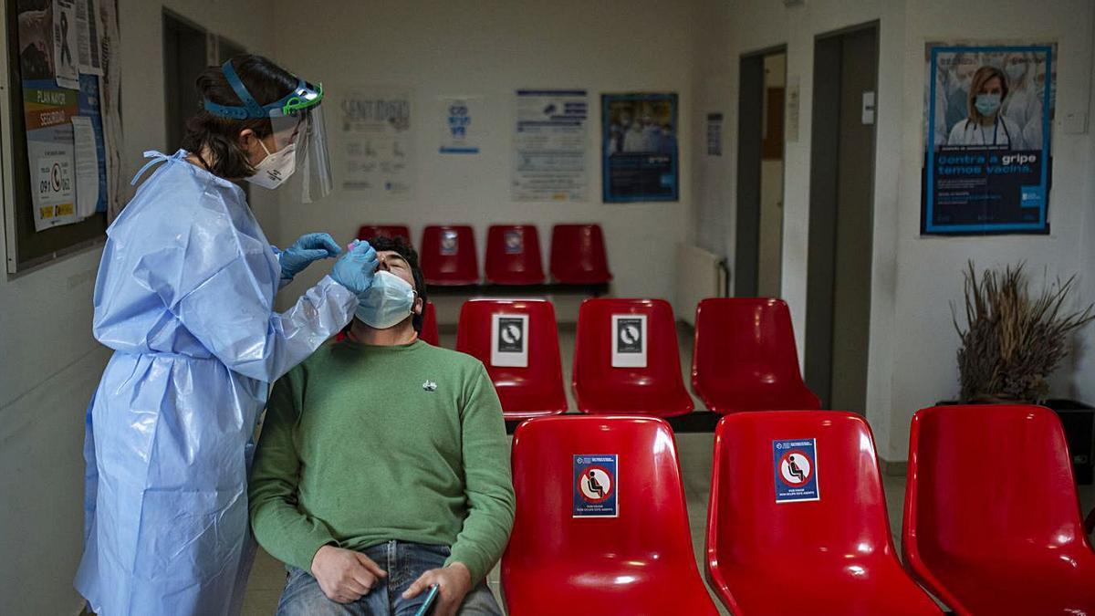 Una trabajadora sanitaria recoge una muestra PCR en el cribado de Beade.