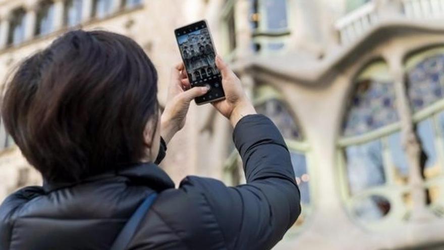 Una turista hace una fotografía con su teléfono móvil.