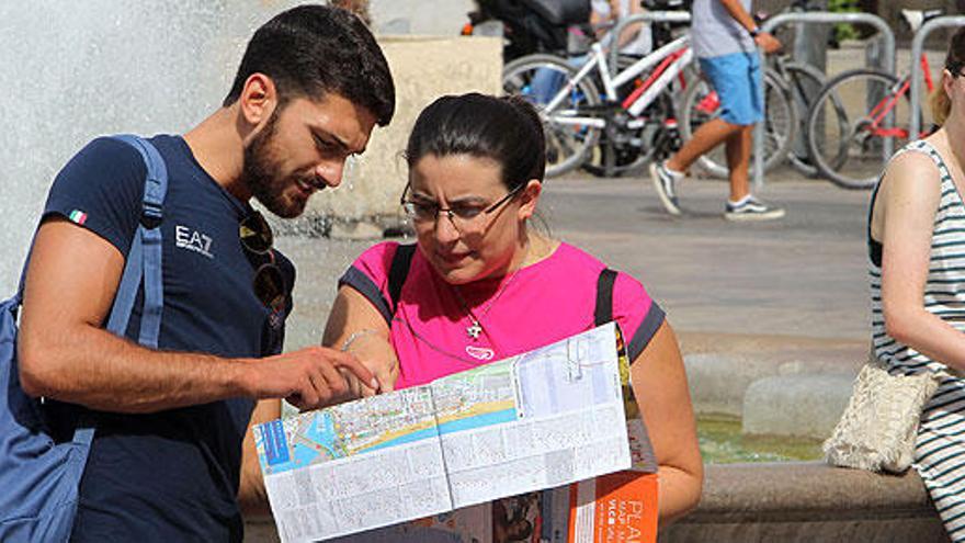 Un hombre y una mujer consultan un mapa.