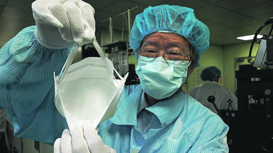 Un empleado muestra una mascarilla en una fábrica de Taiwán.