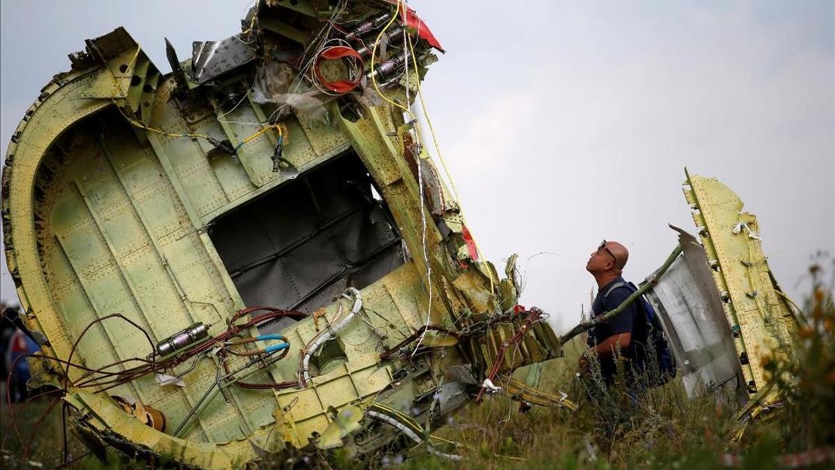 Un investigador inspecciona los restos del avión malasio siniestrado.