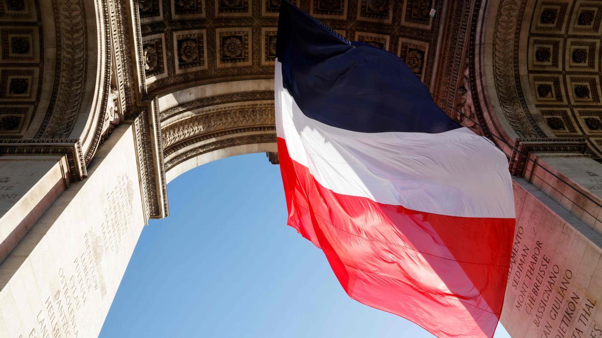 La bandera francesa ondea en el Arco de Triunfo de París.