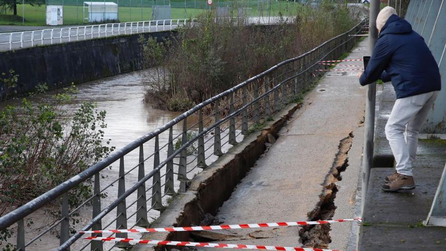 Un hombre fotografía el hundimiento de la senda fluvial del Piles. | Ángel González