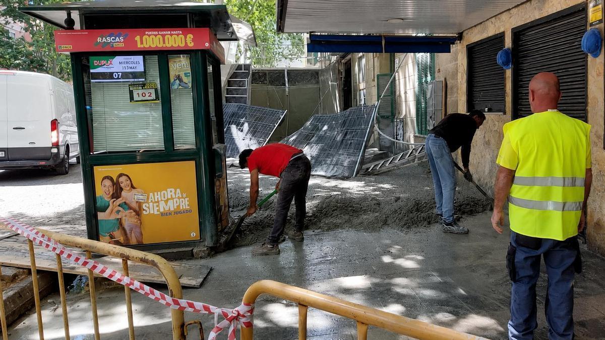 Operarios retirando el hormigón de la acera este jueves.