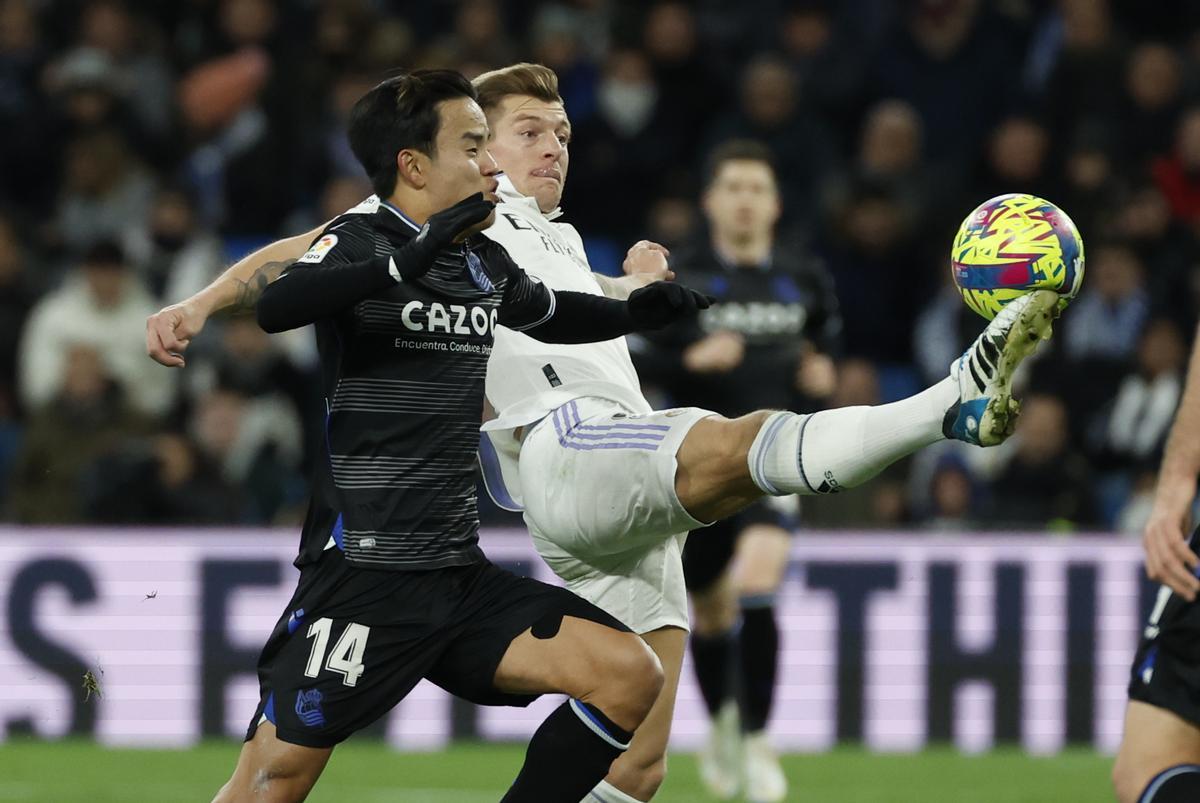 MADRID, 29/01/2023.- El centrocampista alemán del Real Madrid, Toni Kroos (d), disputa el balón ante el centrocampista japonés de la Real Sociedad, Takefusa Kubo, durante el encuentro correspondiente a la jornada 19 de primera división que disputan hoy Domingo en el estadio Santiago Bernabéu, en Madrid. EFE / Juanjo Martín.