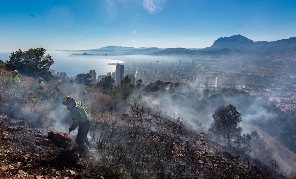 Los bomberos trabajan para sofocar un incendio en el parque de Serra Gelada