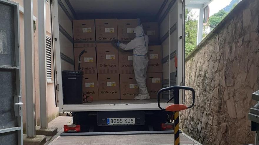 Un operari  amb protecció carrega el camió amb residus biosanitaris del Sant Bernabé