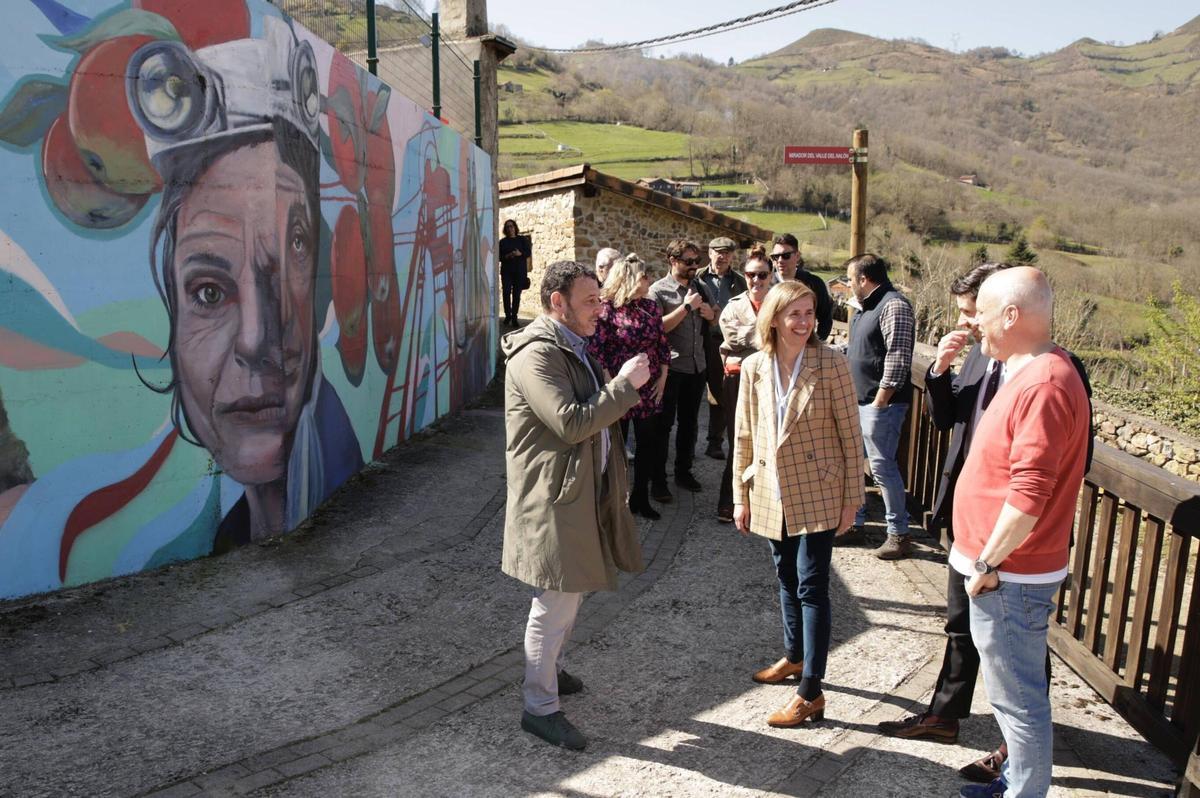 Por la izquierda, Julio García, Eva Pando y David Hevia, junto a uno de los murales de Canzana, en Laviana