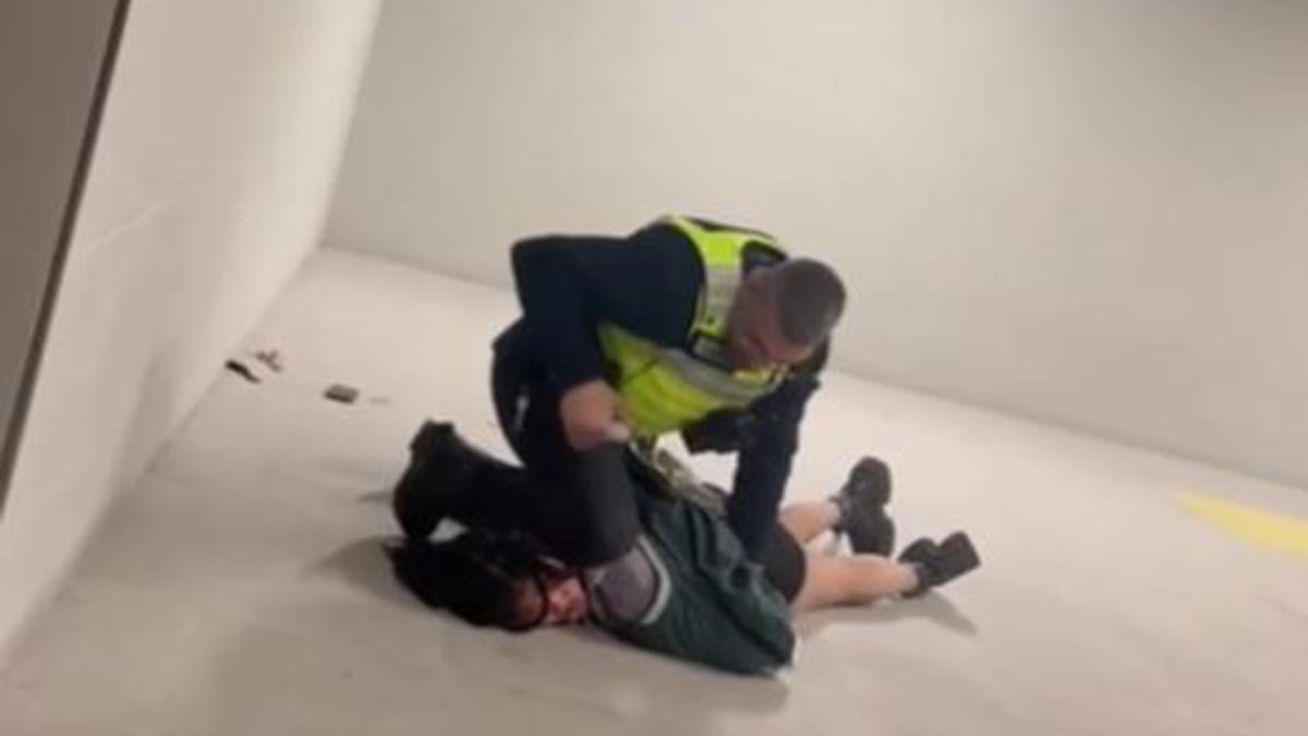 El agente de seguridad mientras le pisa el cuello a la víctima