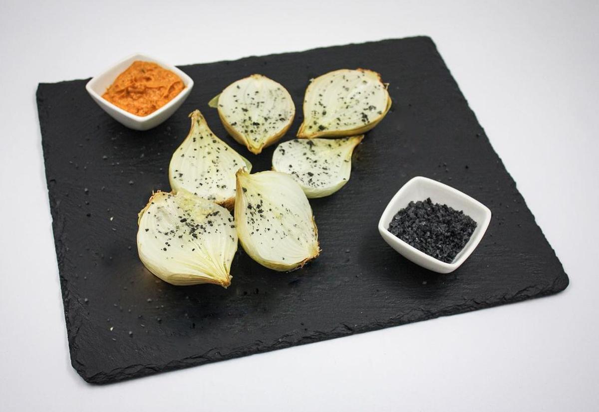 Ración de cebollitas asadas con salsa romescu.