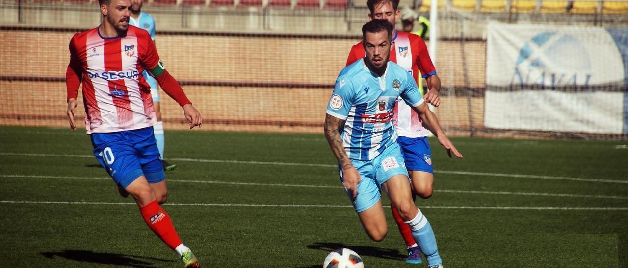 Santi Luque, con el balón, perseguido por dos jugadores del Navalcarnero.