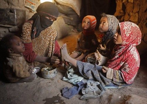Una mujer aplica tinte de henna tradicional en las piernas de sus hijas en su choza en un barrio pobre de la comunidad akhdam cerca de Sanaa 24 de octubre 2012
