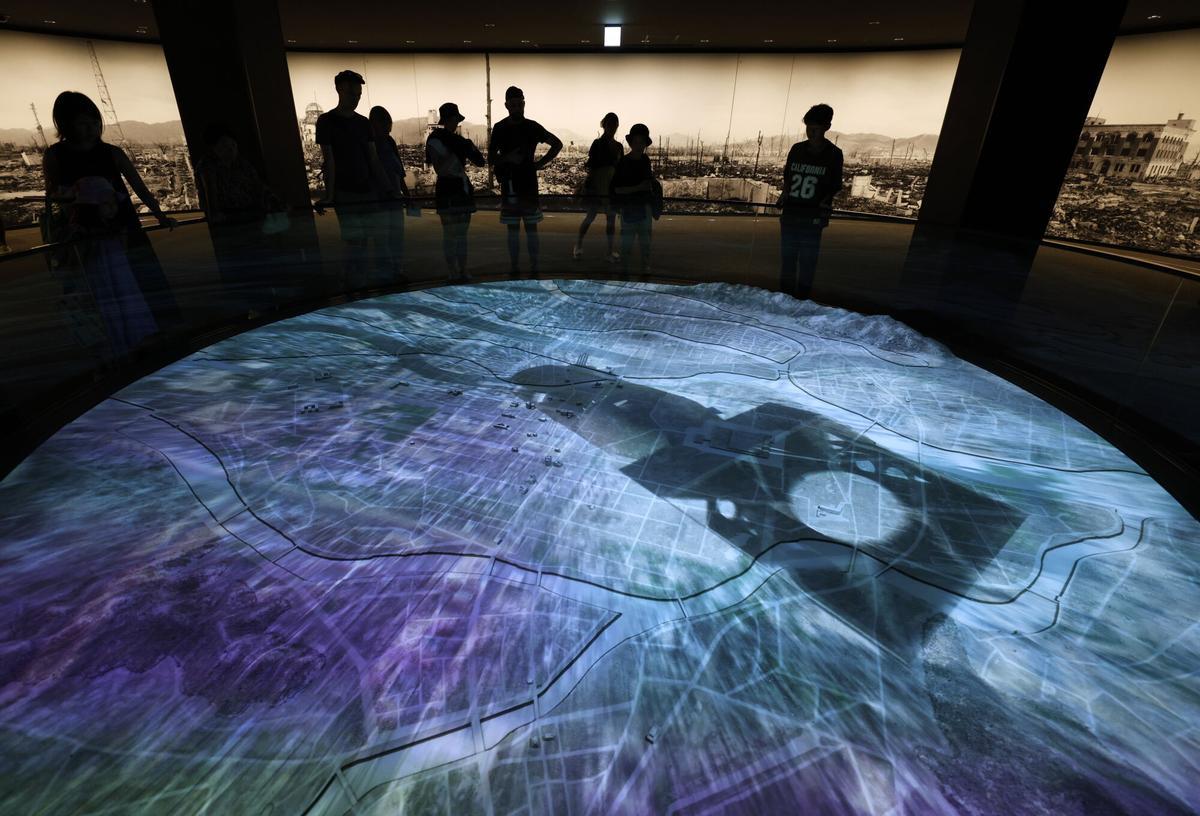 Los visitantes contemplan una animación de la bomba atómica cayendo sobre Hiroshima en el Museo Memorial de la Paz de Hiroshima