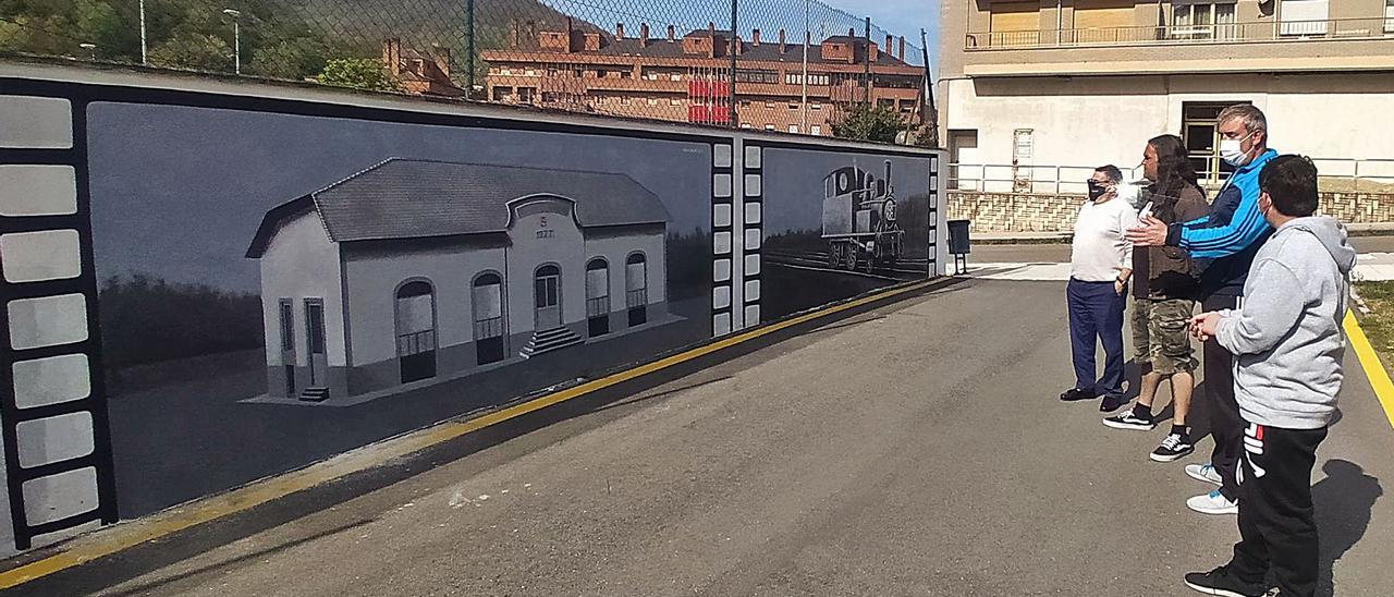 Un grupo de vecinos, junto a David Mariñas, observando el muro que integra los murales. | D. M.