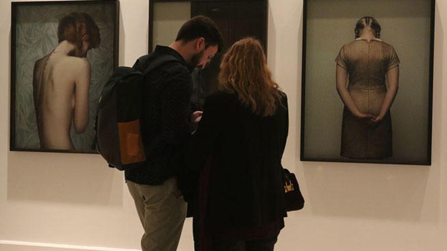 Una pareja observa varias imágenes de la exposición &#039;Celda de emociones&#039;.