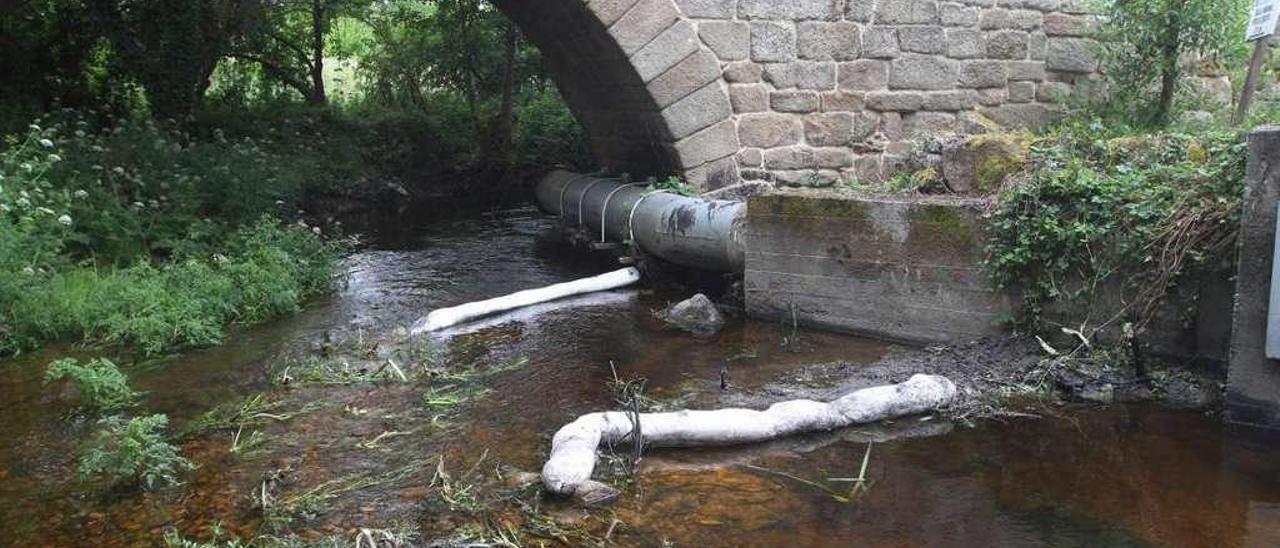 Uno de los últimos vertidos que llegaron al cauce del río Barbaña a su paso por la ciudad, que se controló con balsas. // Iñaki Osorio