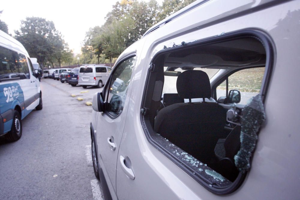 Carrers amb restes de mobiliari urbà cremat, contenidors per terra i treballadors de la brigada treballant