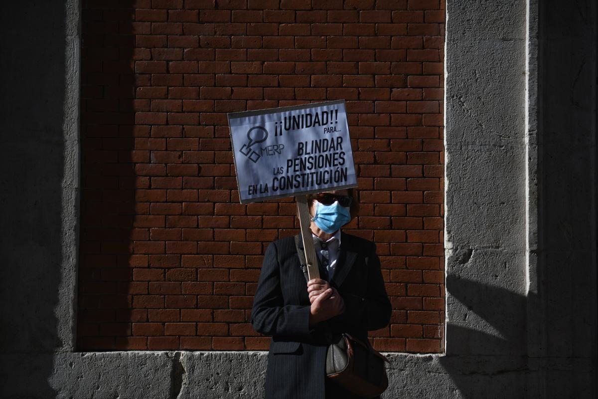 Una mujer sostiene una pancarta durante la manifestación por el blindaje de las pensiones en la Constitución, celebrada en Madrid.