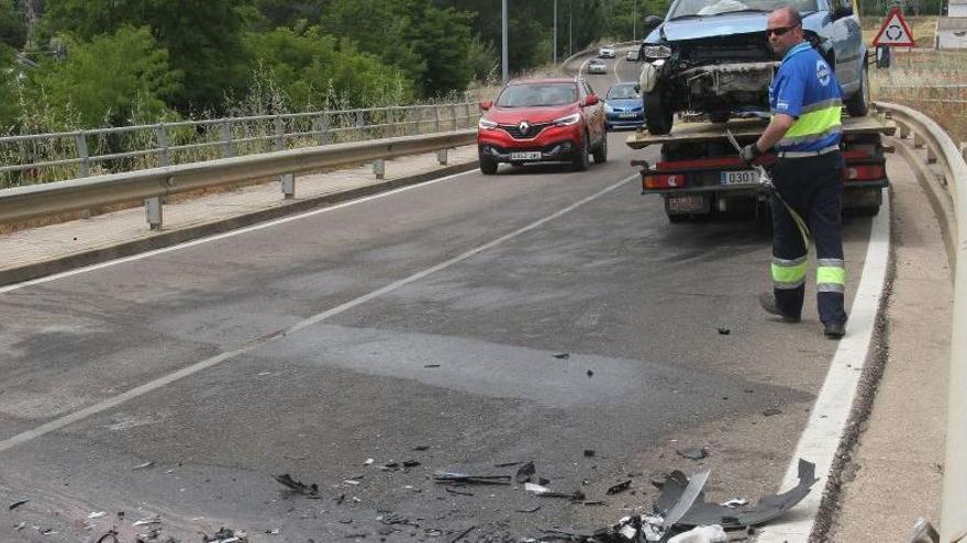 El empleado de una grúa traslada uno de los vehículos implicados.