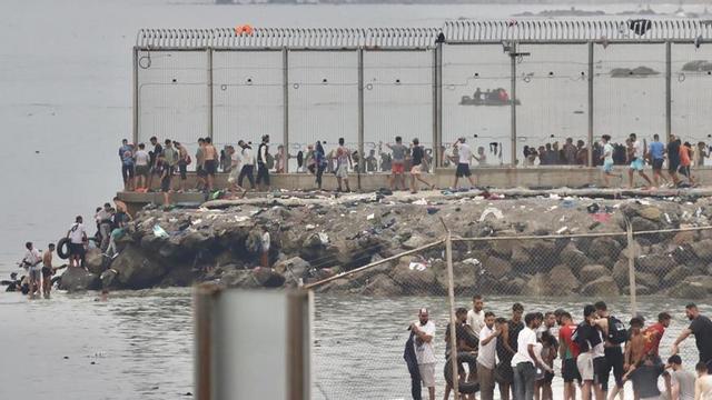 Desenes de migrants intenten travessar la frontera nedant aquest dijous a Ceuta (Espanya).