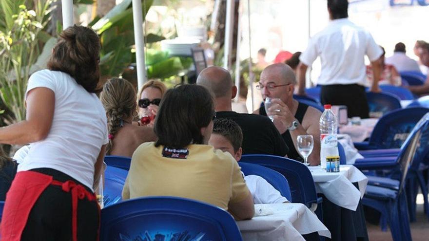 Varios camareros atienden a los clientes de una terraza.