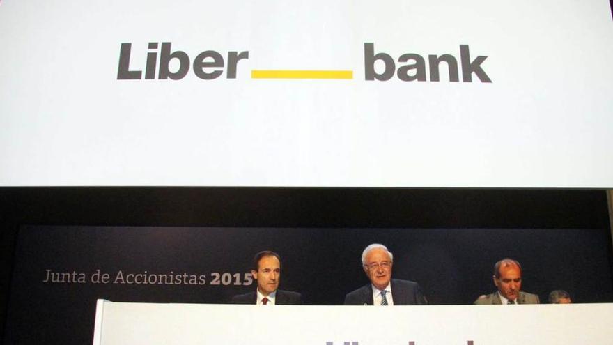 Por la izquierda, Manuel Menéndez (consejero delegado), Pedro Rivero (presidente) y Jesús Alcalde (secretario), durante la junta general de accionistas, ayer, en Madrid. Detrás, la nueva imagen corporativa de Liberbank.