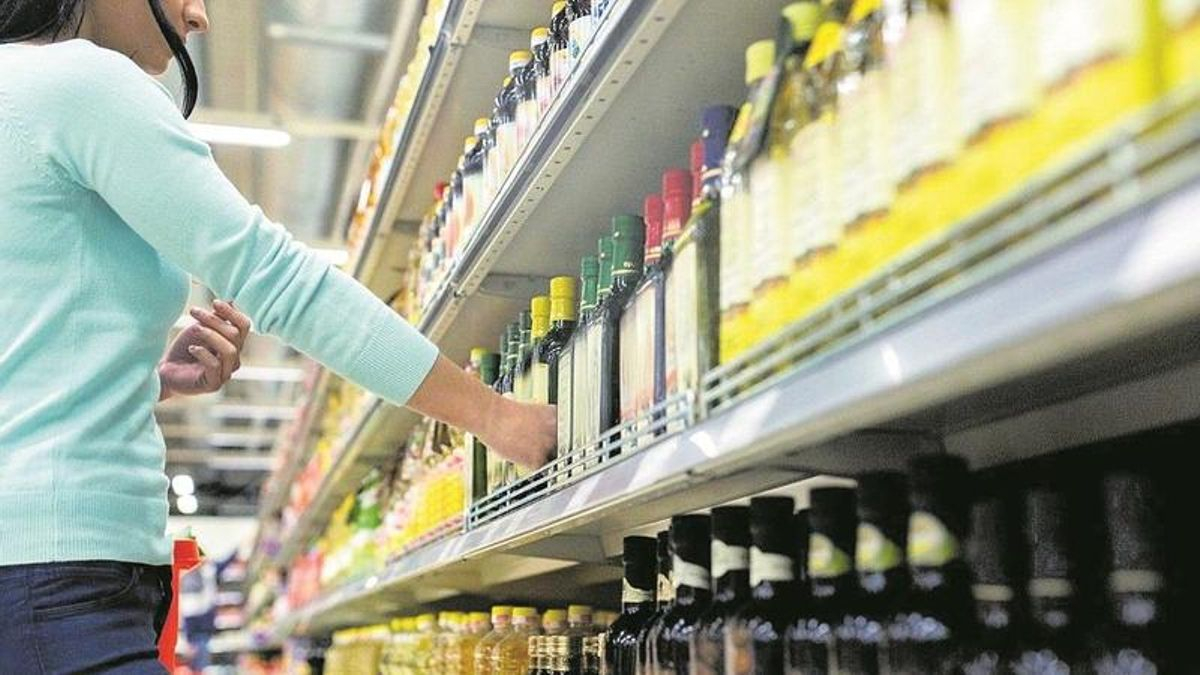 Una clienta, en los lineales de aceite de oliva en los pasillos de un supermercado.