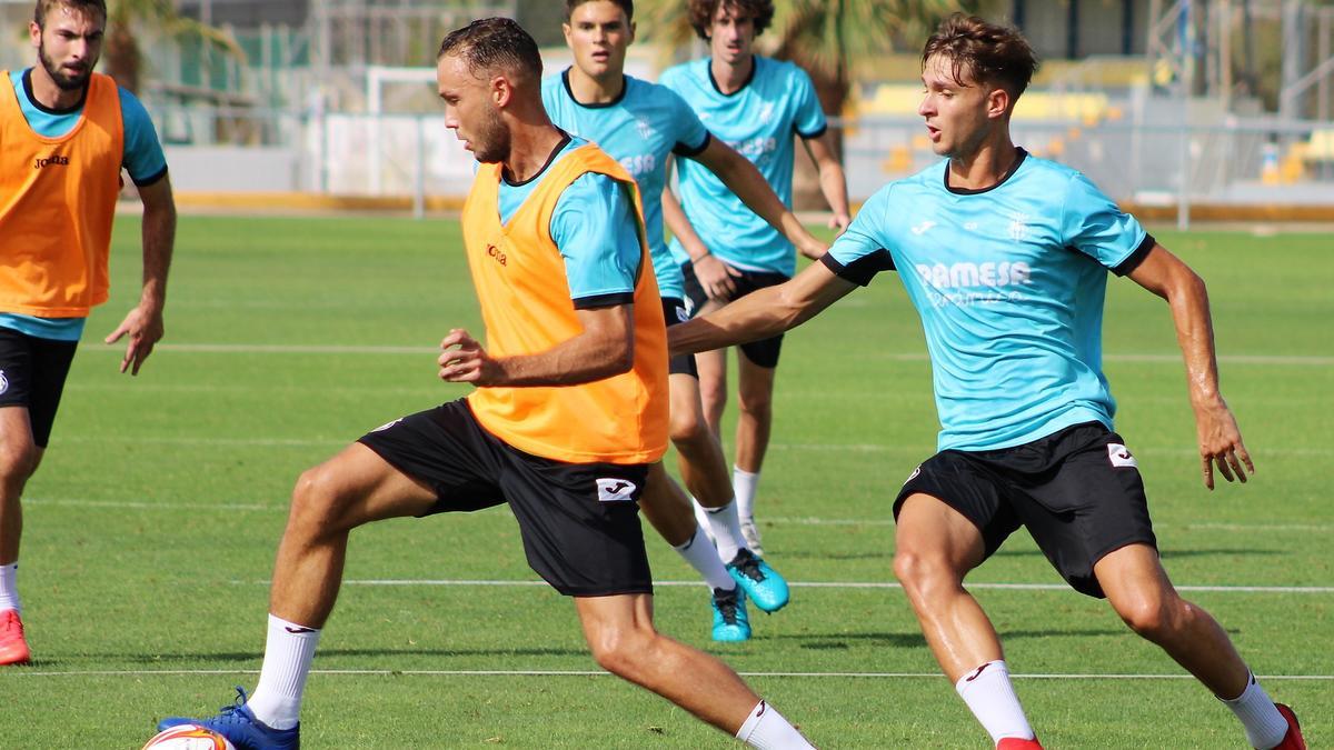 Pablo Íñiguez y Carlo Adriano pelean un balón durante un entrenamiento de esta pretemporada en el campo 9.