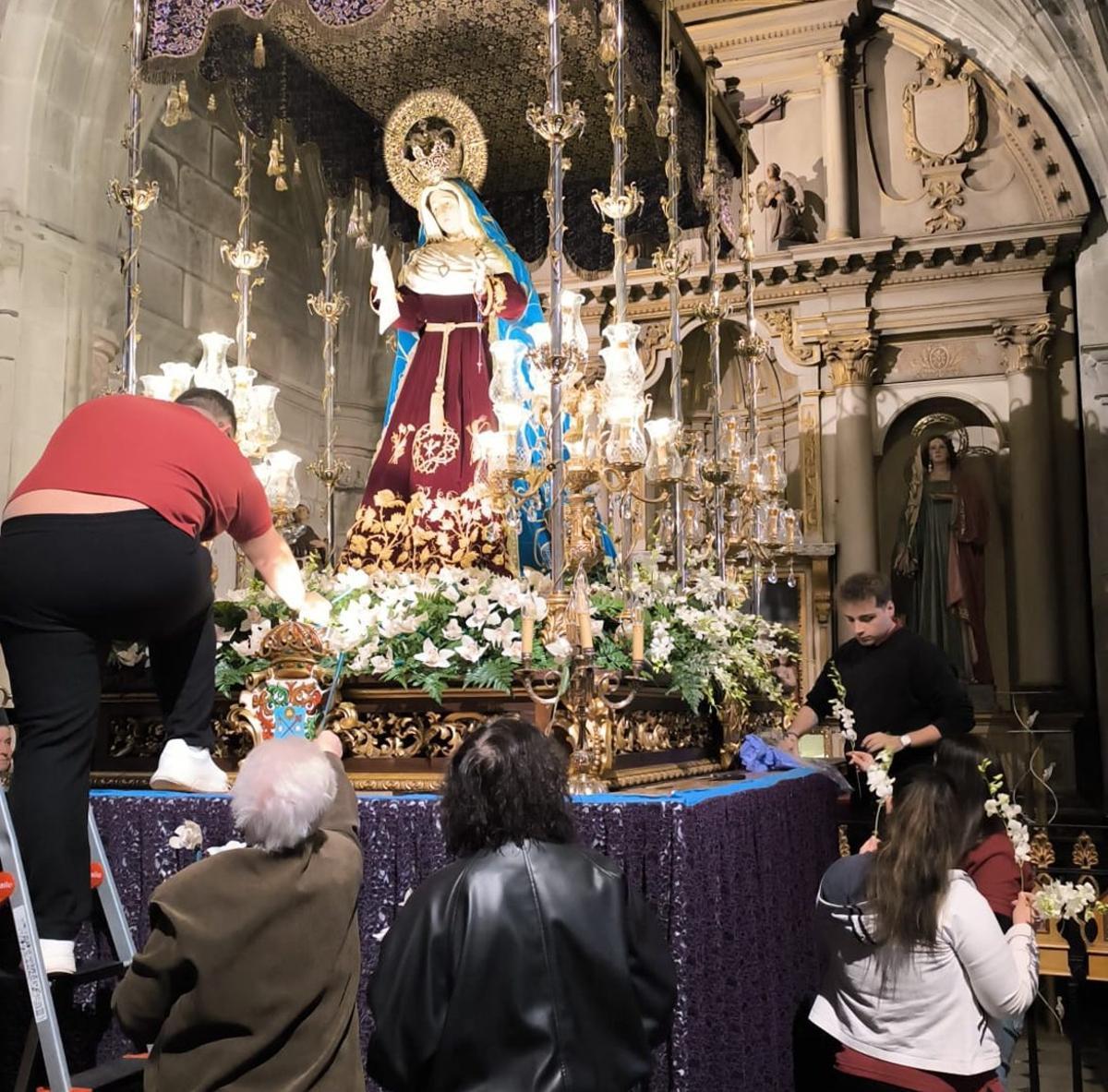 Camareros y camareras de la Virgen, ayer, realizando su trabajo en la excolegiata.