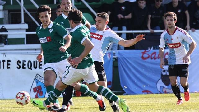 Álex Rey, del Coruxo, lucha por un balón ante la presión de un jugador del Compos. | José Lores