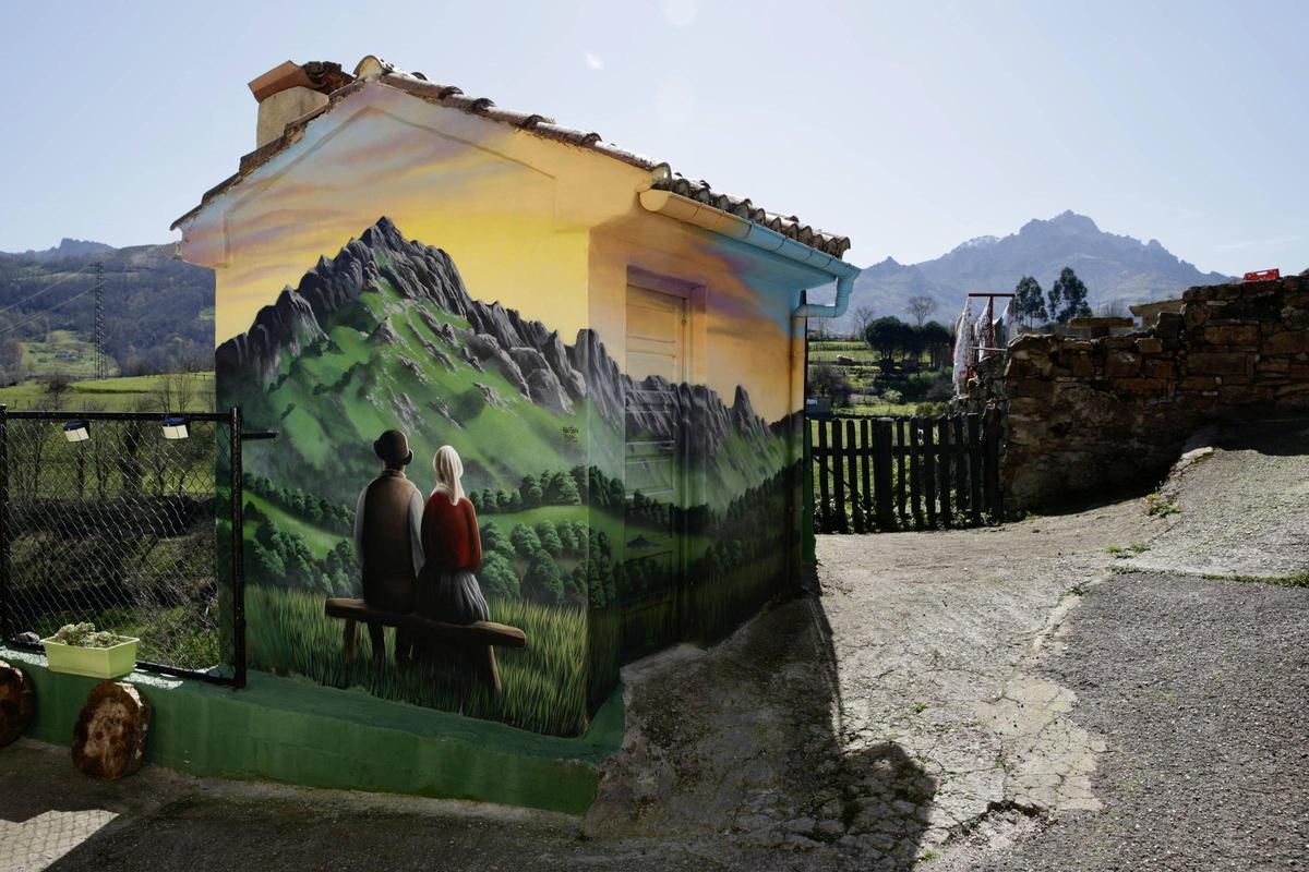 Mural de Bastian Prendes en Canza, Laviana, que representa a Nolo y Demetria mirando a Peña Mea, al fondo