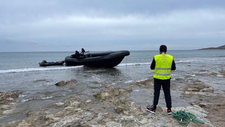 Un agente de la Guardia Civil, junto la planeadora varada en la costa de Cartagena. / LA OPINIÓN DE MURCIA