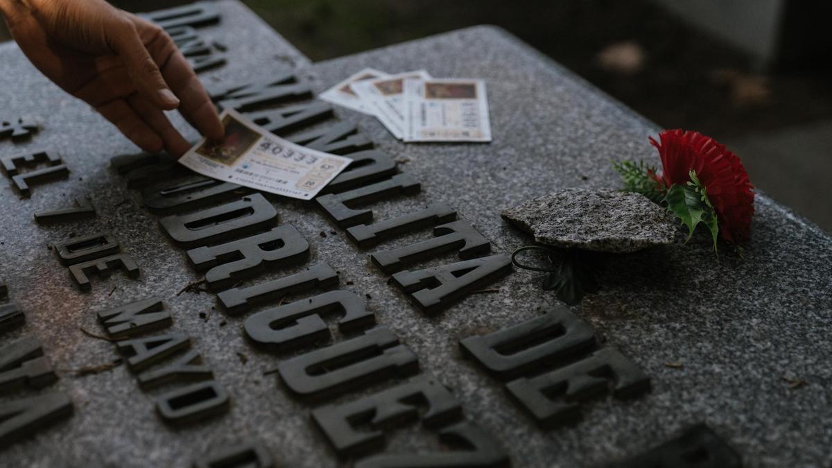 Cada vez más gente visita la tumba de Doña Manolita para 'bendecir' sus décimos de Navidad.
