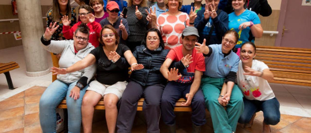 Natacha García y Eugenia Palmés, en el centro de la imagen, junto a usuarios y trabajadores, ayer en su sede de Siete Palmas.