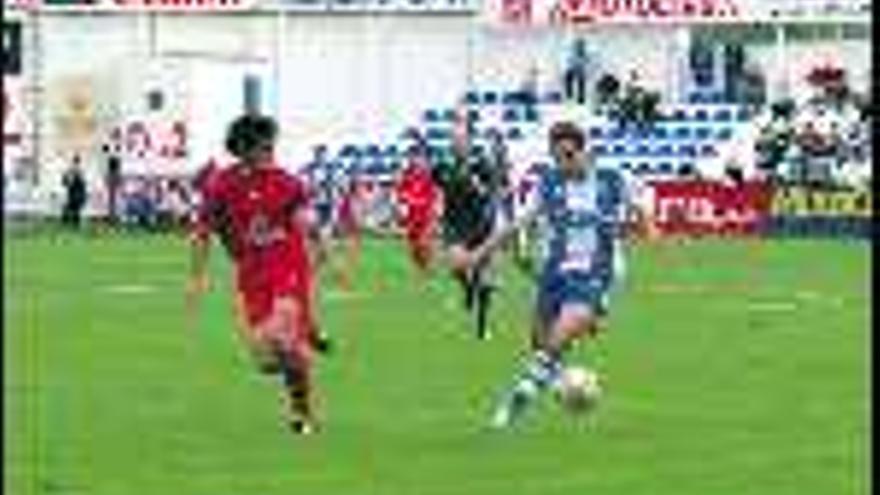 Carlos Calvo

 conduce el balón, perseguido por Mansilla, durante un momento del partido disputado ayer en Alcoy