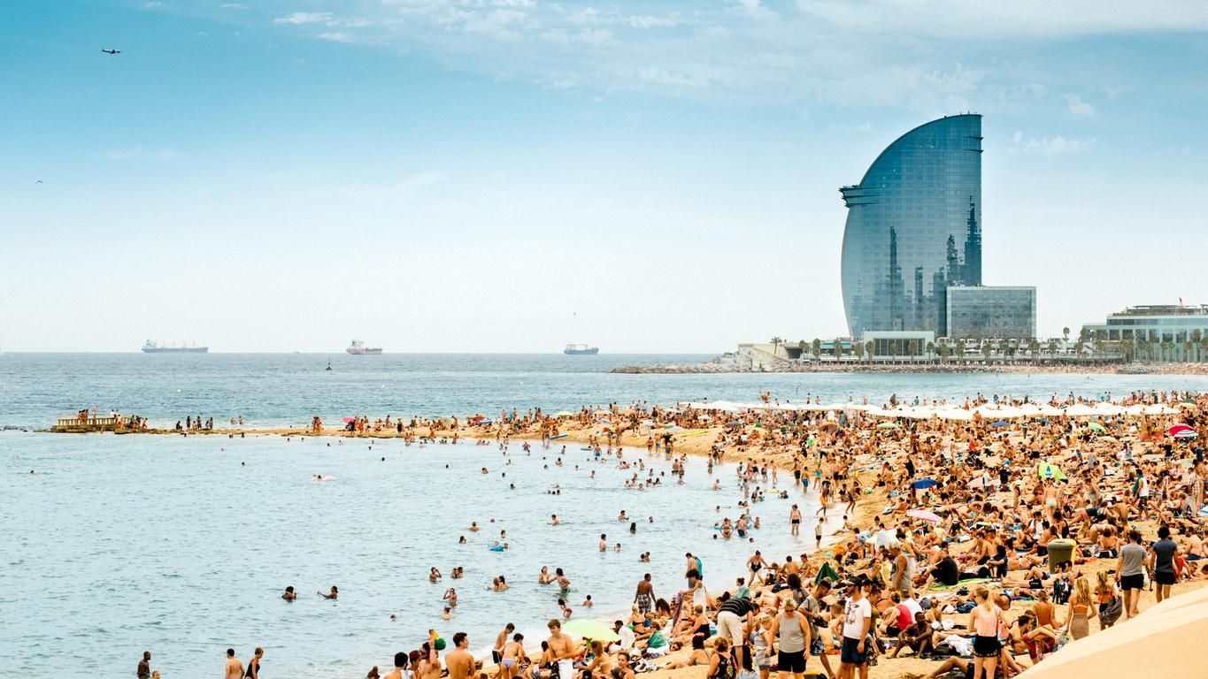 La playa de Barcelona llena de gente.