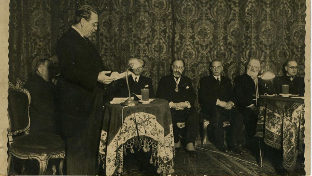 David Fernández Diéguez sentado no centro da fotografía, con barba, no acto de ingreso na Real Academia Galega de Manuel Casás  (13 de marzo de 1936, Arquivo da Real Academia Galega).