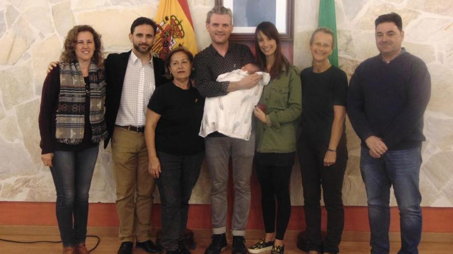 El alcalde de Ojén, José Antonio Gómez, posa orgullos junto a la pequeña Juniper y sus padres.