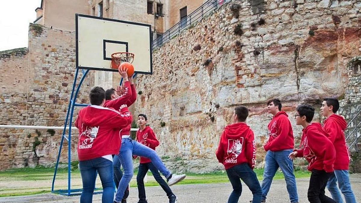 Varios alumnos del seminario menor juegan al baloncesto en sus instalaciones.