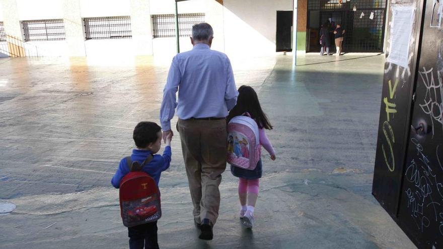 Un padre lleva a sus hijos a un colegio de la capital.