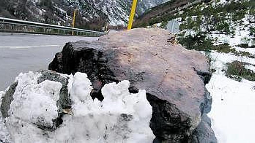 En la imagen superior, la roca desprendida de la ladera. Sobre estas líneas, por la izquierda, José Posada,  Armando Valdés y Sonia Noval.