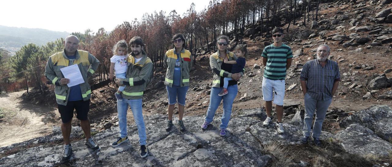 Bomberos forestales de la Xunta, ayer en el monte quemado de Baredo, con el presidente gallego de los comuneros a la derecha. |   // R. GROBAS