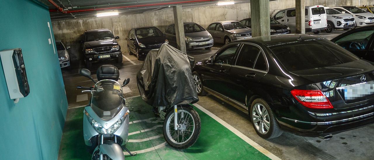 Motos aparcadas en la plaza reservada para recarga de vehículos eléctricos del nuevo parking de Plasencia.