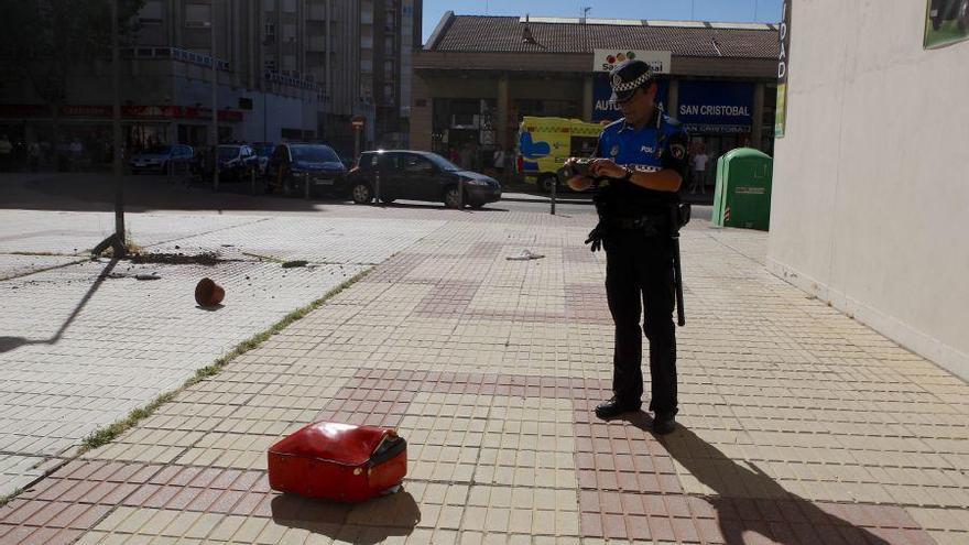 Un policía fotografía la maleta lanzada desde el quinto piso.