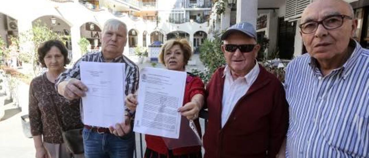 Los vecinos del Rincón Español muestran los autos judiciales que paralizan los trabajos.