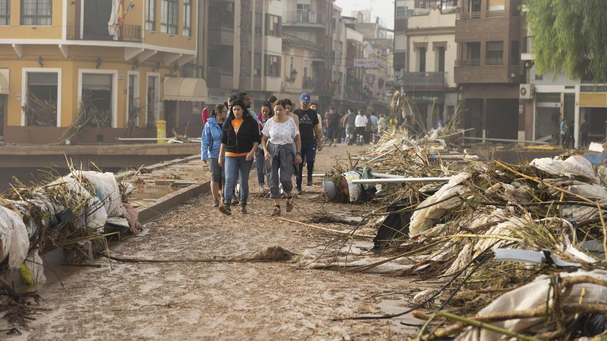 Vecinos de Paiporta caminan entre los destrozos provocados por la Dana.