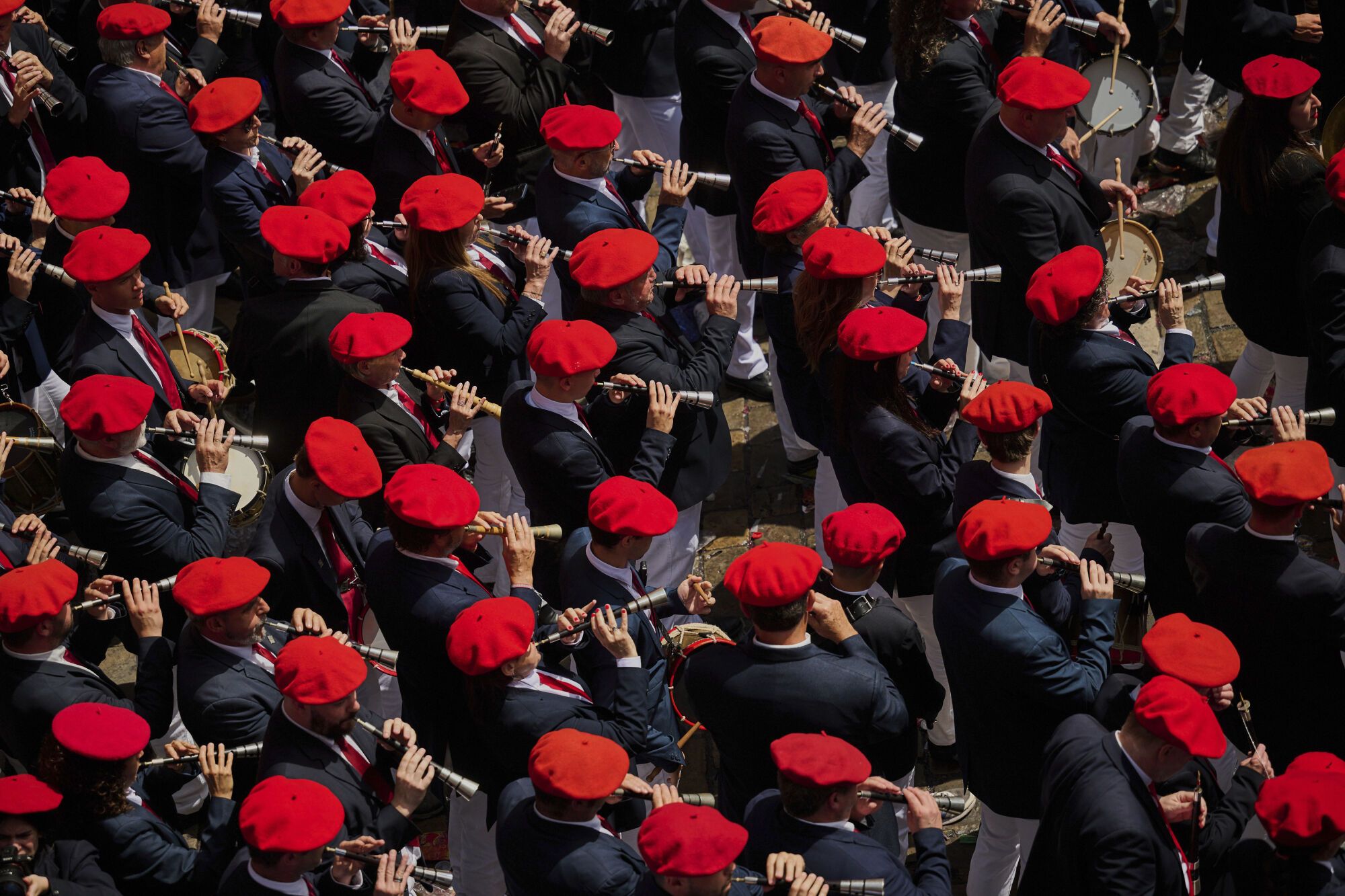 A municipal music band makes it's way through the crowd as revelers pack the main square during the start of nine days of uninterrupted partying in Pamplona's famed running-of-the-bulls festival in Pamplona, Spain, Sunday, July 6, 2025. (AP Photo/Miguel Oses). EDITORIAL USE ONLY/ONLY ITALY AND SPAIN