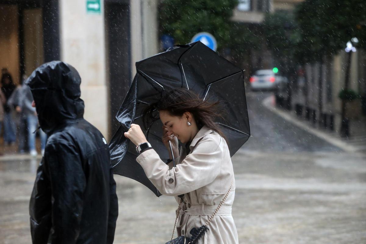 Imagen de transeúntes por el centro de Málaga protegiéndose de la lluvia y el fuerte viento del temporal que barre a toda Andalucía. A 28 de enero de 2026, en Málaga (Andalucía, España).