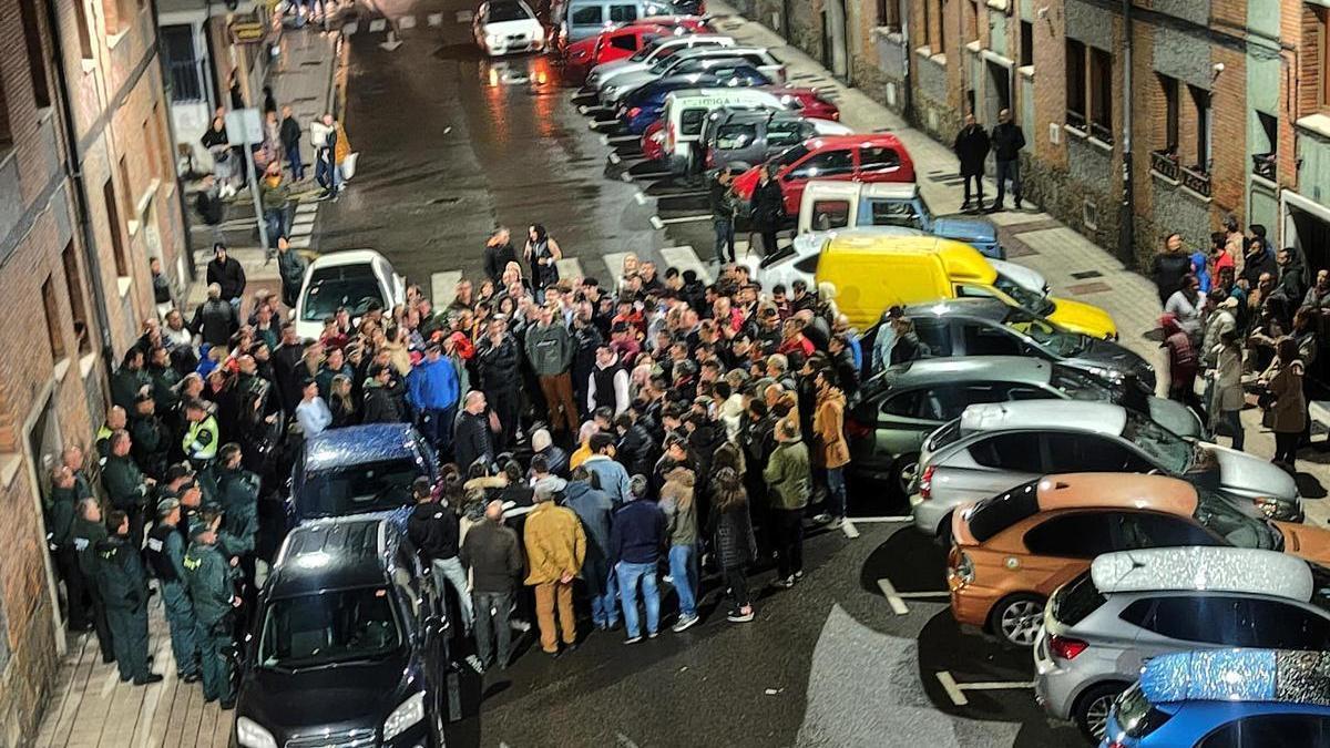 Vecinos concentrados frente a la casa donde vivían los jóvenes, protegida por la Guardia Civil.